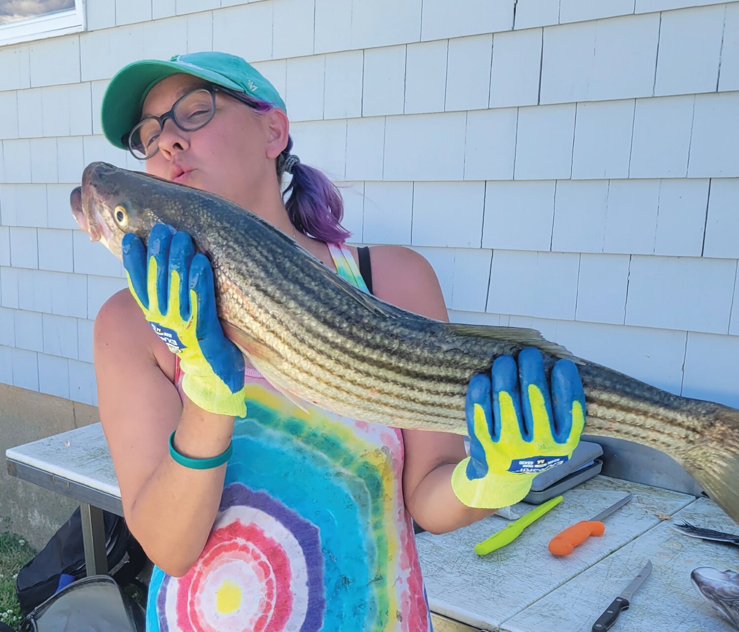 STRIPED BASS GOOD EATING: Katie Spier showing appreciation for her first keeper caught last year while fishing with uncle Greg Spier of Portsmouth. Grilled bass is delicious, the regulation this year is one fish/person/day in a slot size of 28 to less than 31 inches.